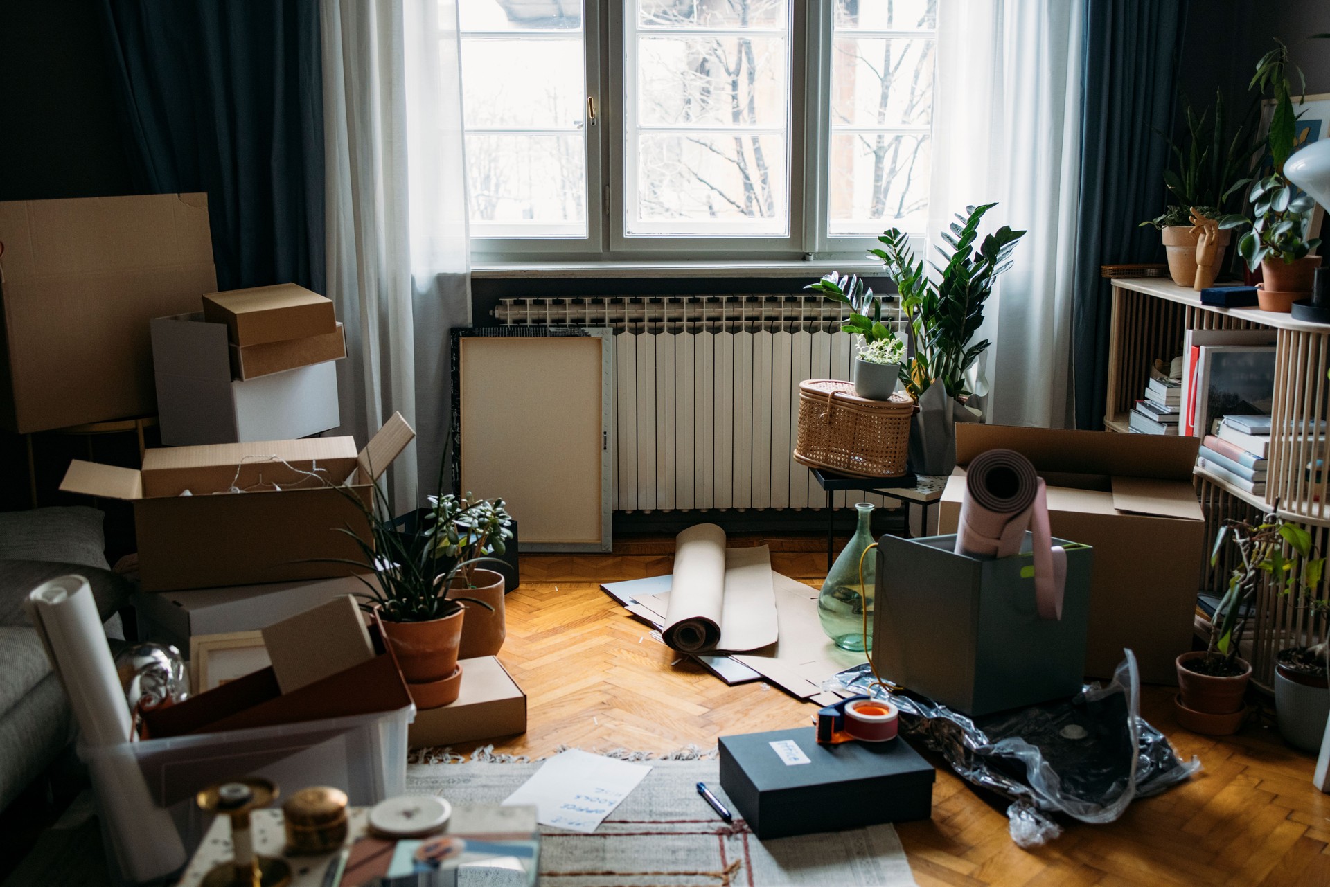 Moving into a New Flat: Cardboard Boxes and Containers Lying all over Living Room